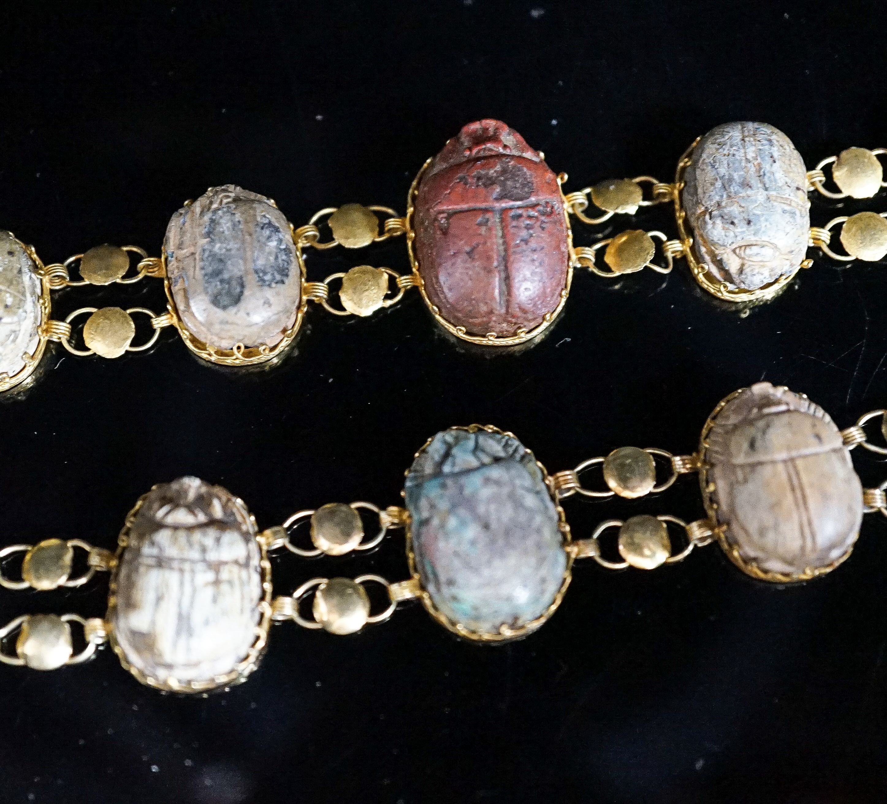 Two similar early 20th century yellow metal mounted scarab bracelets (a.f.), 18.5cm et infra, gross weight 38.1 grams.